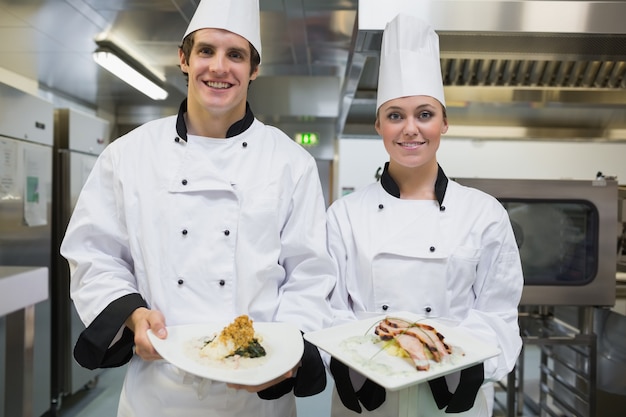 Two smiling Chef&#039;s showing plates