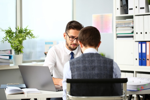 Two smiling clerk businessmen deliberate on problem