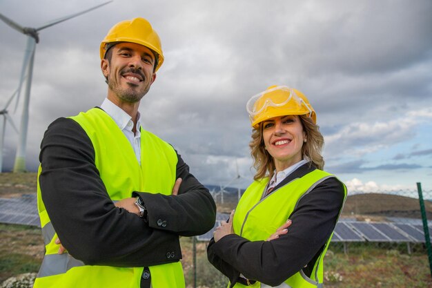 Two smiling engineers with folded arms at a solar power plant