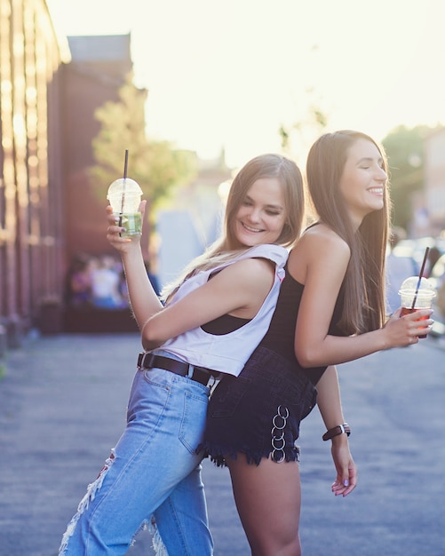 Two smiling girl friends in city