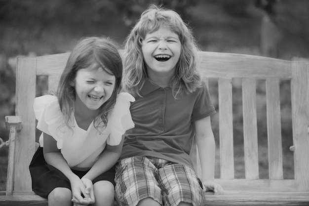 Two smiling laughing kids relaxing outdoors at summer park brother and sister happy walking in natur