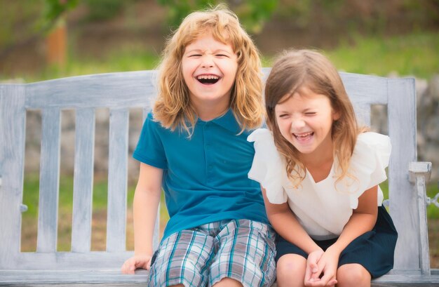 Two smiling laughing kids relaxing outdoors at summer park brother and sister happy walking in