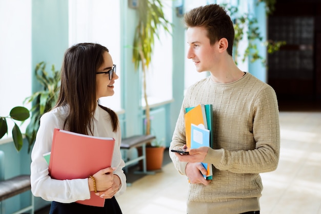 Two smiling students in love communicate during break