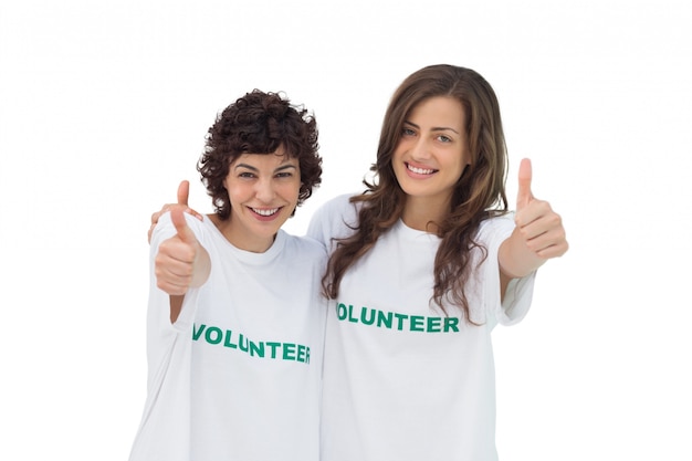 Two smiling volunteers giving thumbs up