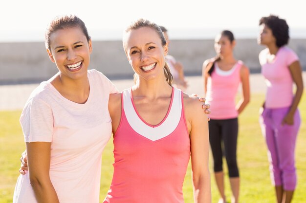 Two smiling women wearing pink for breast cancer