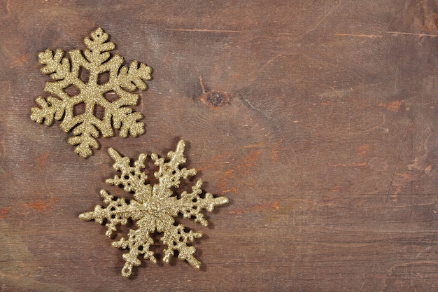 Two snowflakes on a wooden background close up