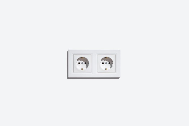 Two sockets in a white frame on a white wall