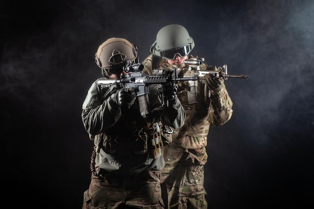 Two soldiers in military uniform with weapons in a special operation at night