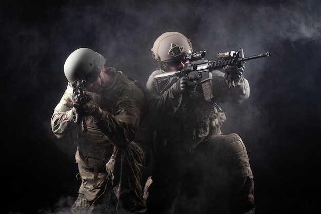 Two soldiers in military uniform with weapons in a special operation at night