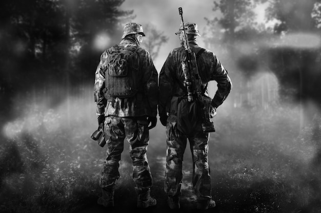 연기가 자욱한 숲 속에 특수부대의 두 병사가 서 있다. 혼합 매체