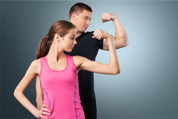 Two sportive people in black sportswear showing their biceps,