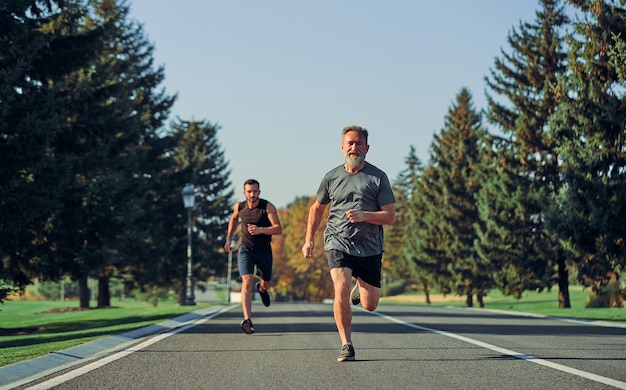 道路を走っている2人のスポーツマン