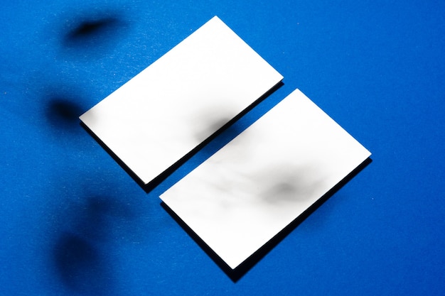 Two stacks of blank businesscards on blue background