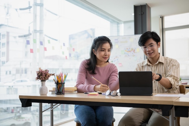 Two startup employee consulting with digital tablet in modern office