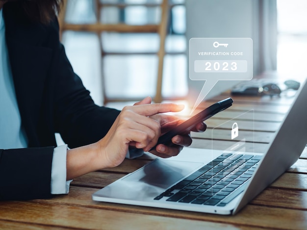 2段階認証2FAコンセプト2023パスワードの検証Webページにコンピューターを使用している間、スマートフォンの検証コードとキーアイコンアラート身元検証サイバーセキュリティ技術