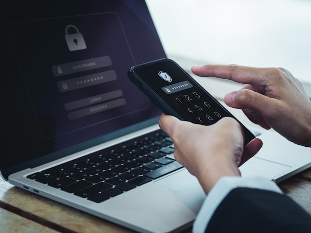 Two steps authentication 2FA concept Shield icon and password code showing on smart phone screen while businessperson login on laptop computer Identity verification cybersecurity technology