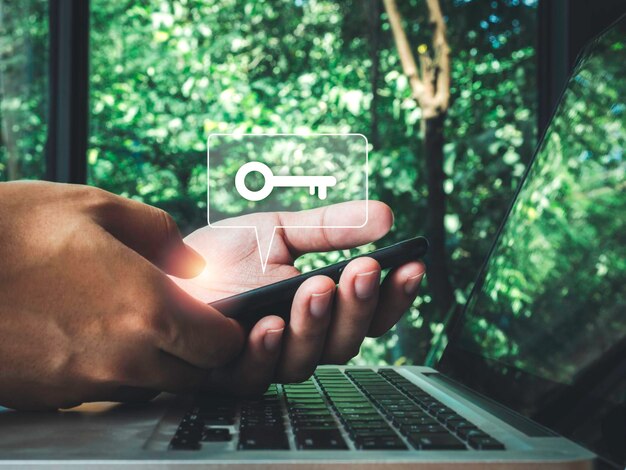 two steps authentication concept. virtual key icon on smartphone while using laptop for validate password, identity verification, cyber security on internet with biometrics authentication technology.