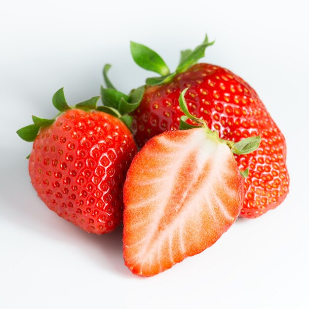 Two strawberries and a half on a white background