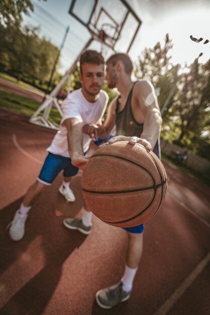 Two street basketball players having training outdoor. They are making a good action.