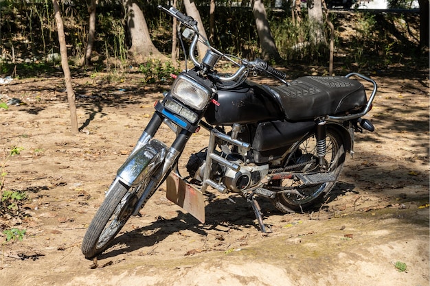 A two stroke bike parked in the wild closeup