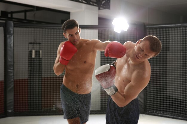 Photo two strong boxers fighting in gym
