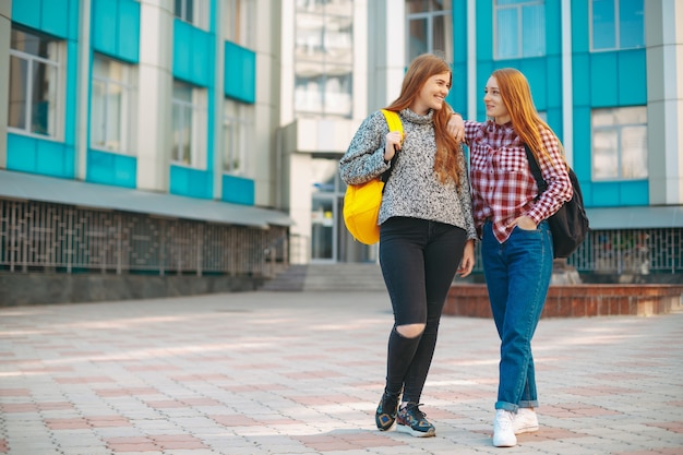 Photo two student female friends walking from university