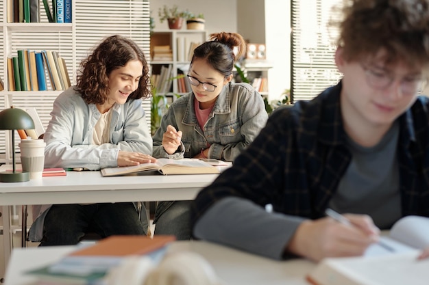 Two students boy and girl at desk in college class preparing for exams