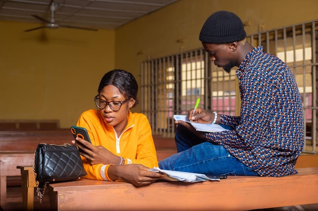 Two students reading a book together in classroom