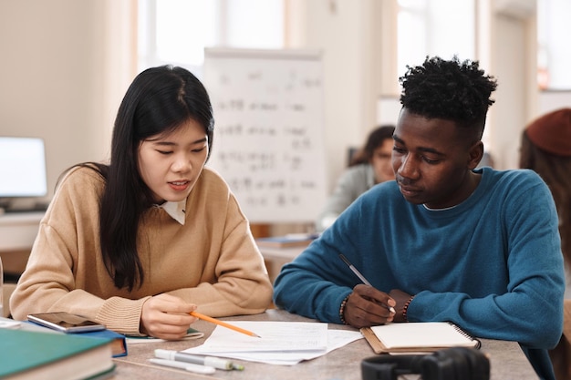 Two students studying at table in library