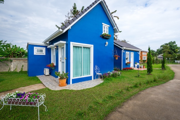 Due stili di casa blu decorati con giardino anteriore e vaso di fiori. stile casa, semplice de