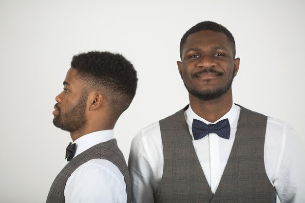 Photo two stylish african men in suits on white wall