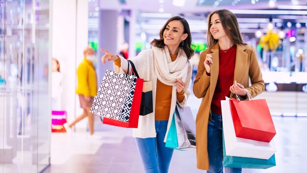 Two stylish confident women during shopping in the mall