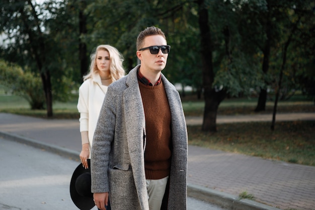 Two stylish, man and woman are walking on the street.