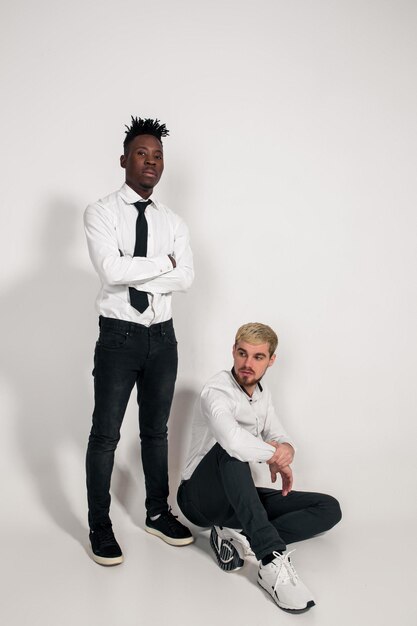 Two stylish men posing and having fun on white background