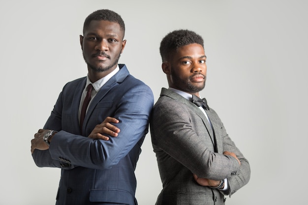 two stylish men in suits on a gray background