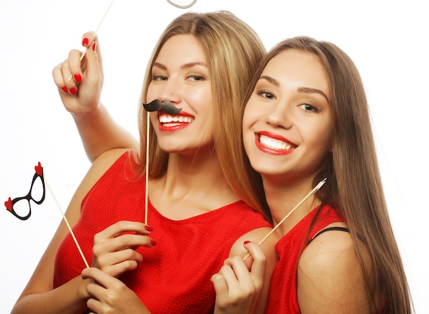 Two stylish sexy girls best friends wearing red dress ready for party, over white background