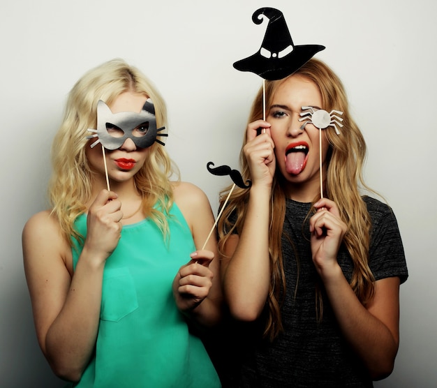 Two stylish sexy hipster girls best friends ready for party, over gray background