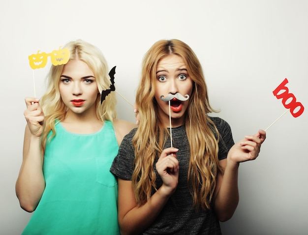 two stylish sexy hipster girls best friends ready for party over gray background