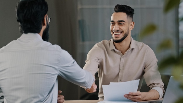 Two successful diverse business men colleague arabian salesman banker male manager shaking hand