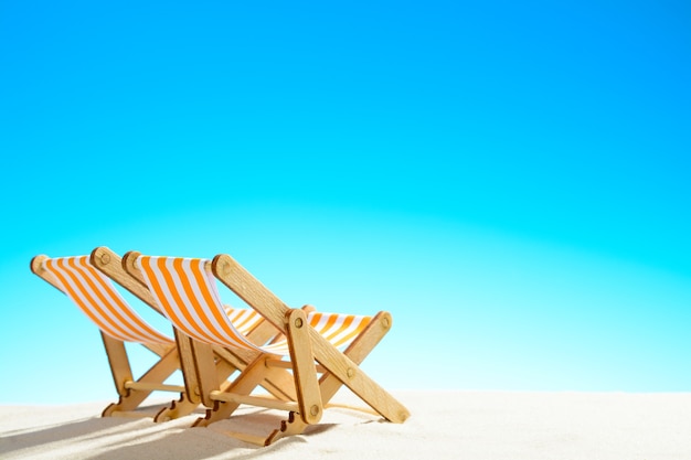 Photo two sun loungers on the sandy beach