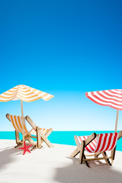 Two sun loungers under an umbrella on the sandy beach by the sea