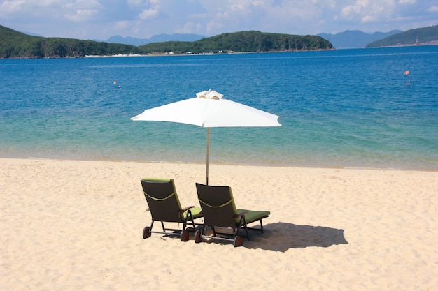Two sun loungers under an umbrella on the sea