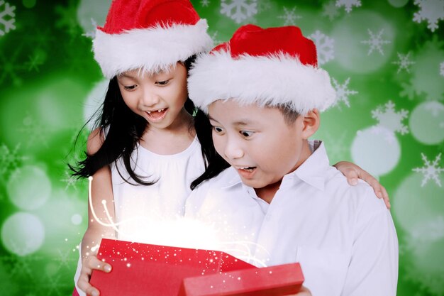 Photo two surprised children open christmas present