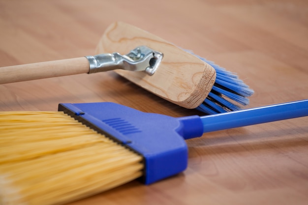 Two sweeping brooms on wooden floor