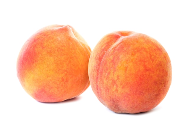 Two sweet juicy peaches isolated on white background