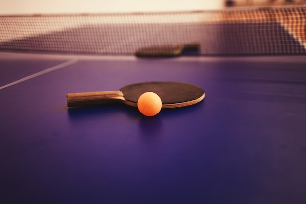 Two table tennis rackets on blue table