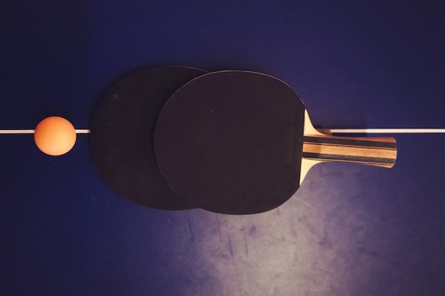 Foto due racchette di ping-pong sulla tavola blu