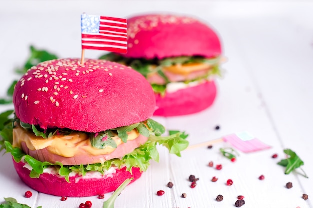 Photo two tasty hamburgers with little american flags