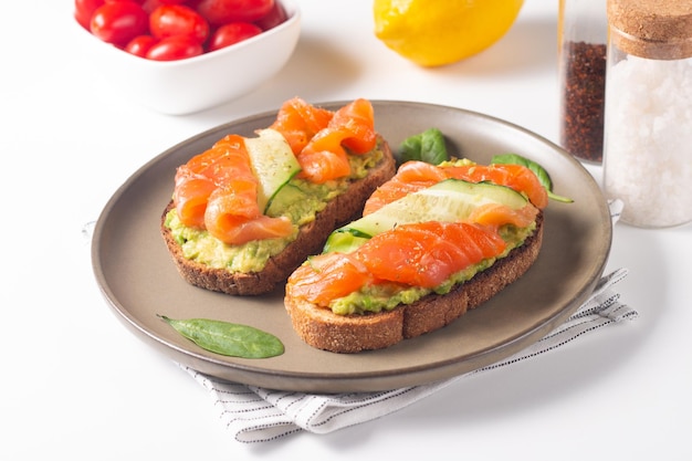 Due gustosi panini al salmone aperti con avocado e cetriolo. mattina sana colazione. vista dall'alto.