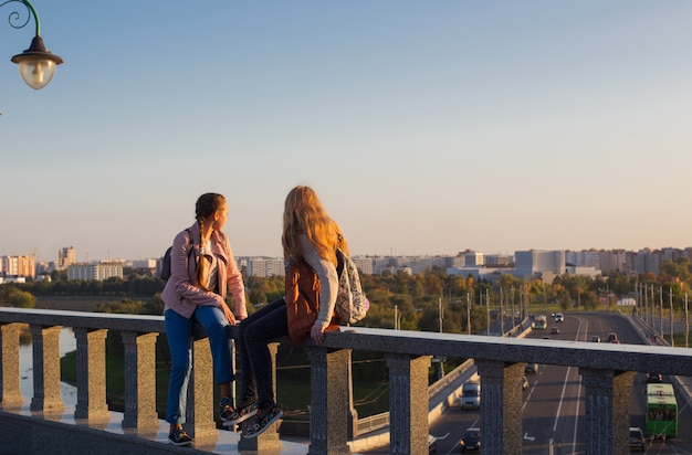 Two teen girls on a bridge in the  sity